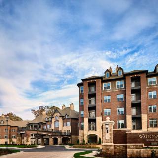 A view of luxury residential apartments with a clear blue sky and scattered clouds.