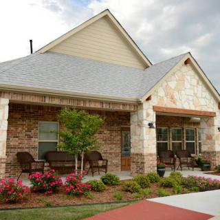 A cozy residential house with a brick exterior and a landscaped garden.