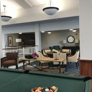 A cozy lounge area featuring a pool table and comfortable seating.
