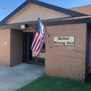 Entrance of a Skilled Nursing Unit with an American flag.