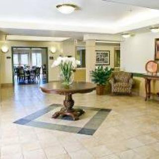 A spacious lobby featuring a round table with flowers and comfortable seating arrangements.