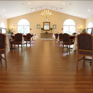 A spacious dining room with elegant furniture and a chandelier.