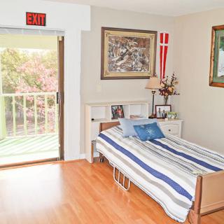 A cozy bedroom with a single bed, striped bedding, and a balcony view.