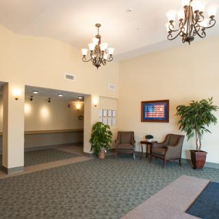 A well-lit lobby area with seating and decorative chandeliers.