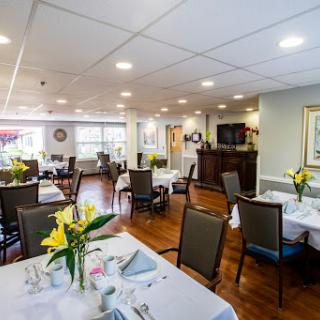A well-lit dining area featuring elegant tables set with flowers.