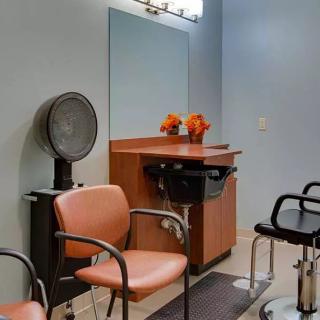A well-organized hair salon interior with chairs, a large mirror, and flower decorations.