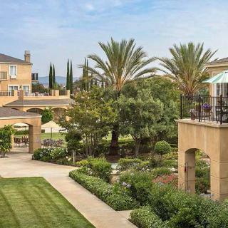 A luxurious resort featuring elegant architecture and beautifully landscaped gardens with palm trees.