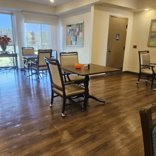 A cozy dining area featuring wooden furniture and ample natural light.