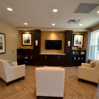 A cozy living room with modern seating and a central entertainment system.
