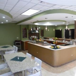 A modern cafeteria interior with dining tables and a serving counter.