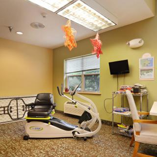 A therapy room with a stationary bike and rehabilitation equipment.