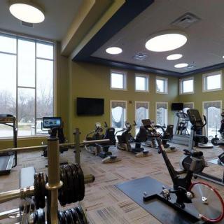 A modern gym with various exercise equipment and cardio machines.