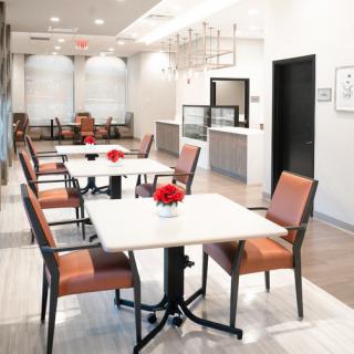 A modern and clean dining area with several tables and chairs, featuring minimalist decor.