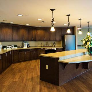 A modern kitchen with wooden cabinets and pendant lighting.