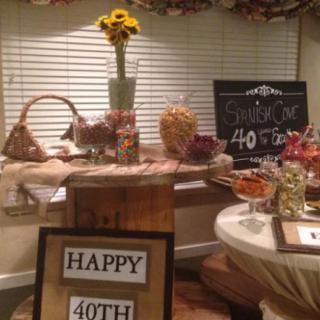 A rustic-themed setup for a 40th birthday party with snacks and a chalkboard sign.