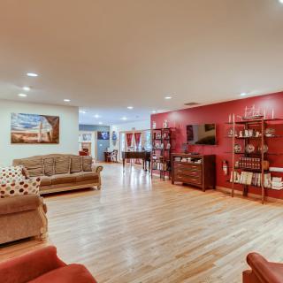 Spacious and stylish living room with red accents and hardwood flooring.