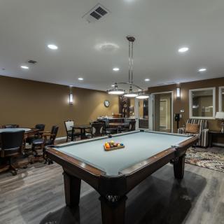 A modern recreation room featuring a pool table and stylish lighting.