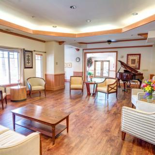 A cozy living room with a piano and comfortable seating area.