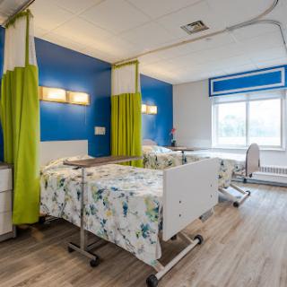 A modern hospital patient room featuring clean lines and bright colors.