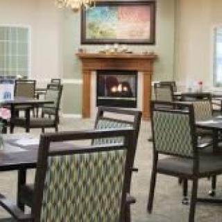 A cozy dining area featuring a fireplace and elegantly arranged tables and chairs.