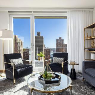 A stylish modern living room with a stunning cityscape view through large windows.