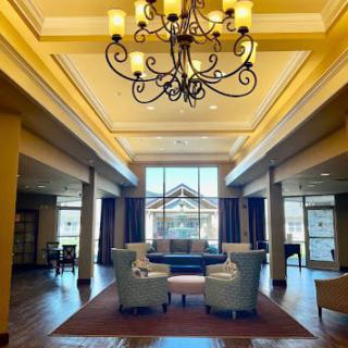 A well-lit lobby with elegant seating and a central chandelier.