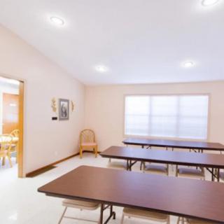 A meeting room with tables and chairs arranged in a bright, well-lit interior.