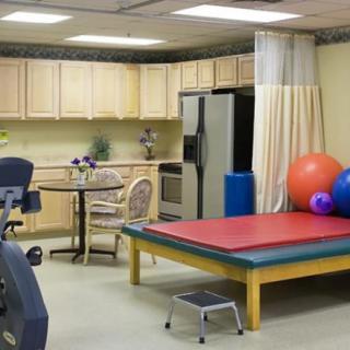 A therapy room equipped with exercise balls, a therapy bed, and fitness equipment.
