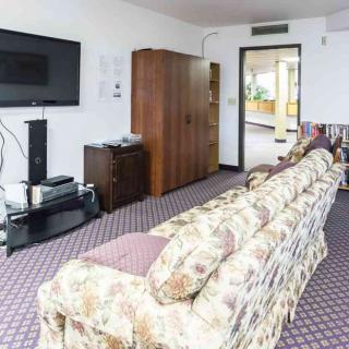 A cozy living room with a floral sofa and a flat-screen TV.