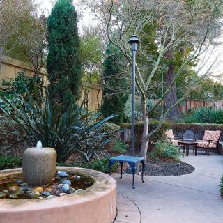 A serene garden with a small fountain and outdoor seating area.