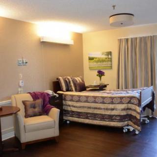 A well-decorated bedroom with a single bed, a comfortable armchair, and elegant wall art.