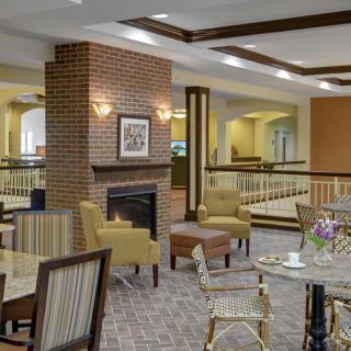 A cozy lobby seating area featuring a fireplace and comfortable armchairs.