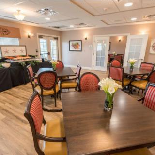 An elegant dining area with neatly arranged tables and chairs, adorned with floral centerpieces.
