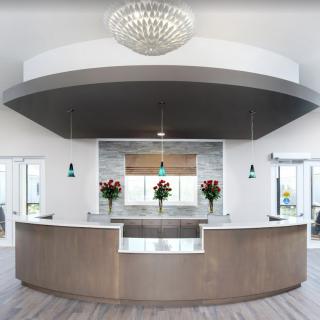 A modern reception area with a curved counter and elegant decor.