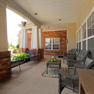 A cozy patio with comfortable seating and greenery, perfect for relaxation.