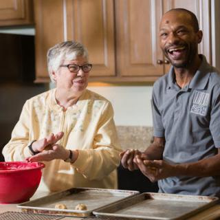 A joyful moment in the kitchen as two friends enjoy baking together.