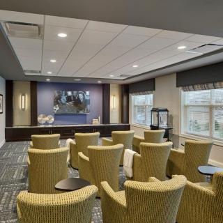 A modern conference room with arranged seating and a projector screen.