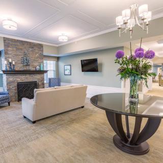 A modern living room featuring elegant decor with a chandelier, fireplace, and comfortable seating.