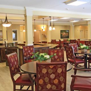 A well-lit and elegantly furnished dining area with multiple tables and chairs.