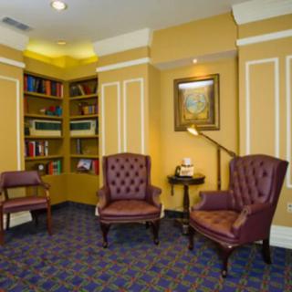 A cozy library corner with armchairs and bookshelves.