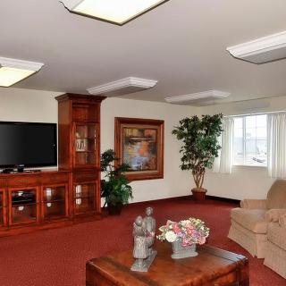 A cozy living room featuring a large television, comfortable seating, and elegant decor.