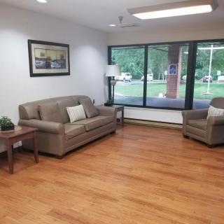 A cozy living room with a sofa, armchair, and hardwood floors.