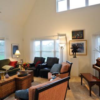 A cozy living room with comfortable seating and a piano.