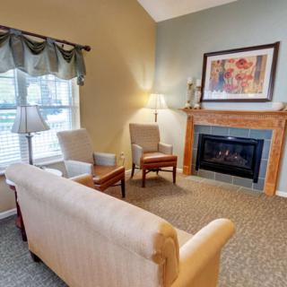 A cozy living room with a sofa, chairs, and a fireplace.