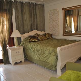 A cozy bedroom with a green theme and classic furnishings.