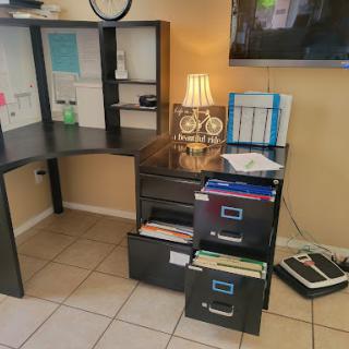 A well-organized home office setup featuring a desk, filing cabinets, and a lamp.