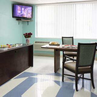 A modern dining area with a table, chairs, and a wall-mounted TV.