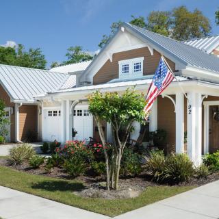 A suburban house with a garden and an American flag displayed outside.