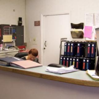 A reception desk in an office setting with organized files and paperwork.