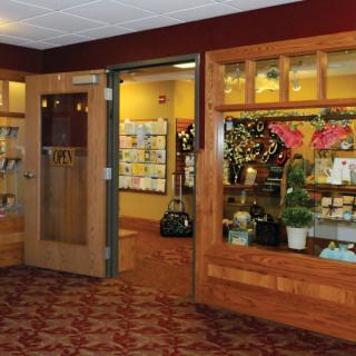 An inviting gift shop entrance with wooden display windows showcasing assorted gifts and greeting cards.